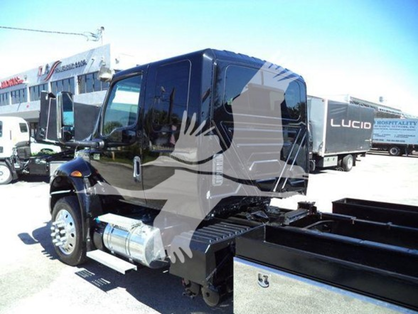 Truck cab with rollback equipment showing side mirrors, fuel tank, and chassis; visible text includes none legible from image.