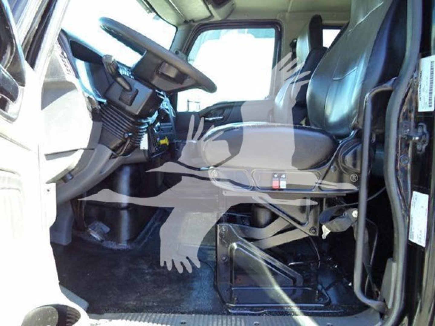 Cab interior of a 2022 International MV truck showing driver seat, steering wheel, dashboard, and passenger seat.