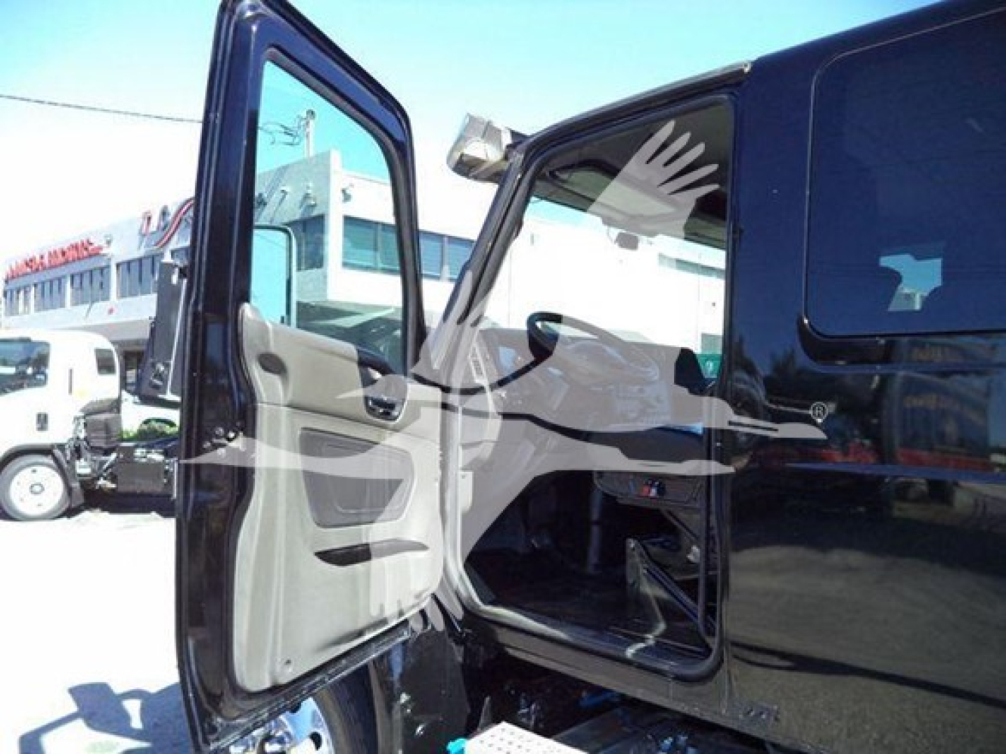 Truck cab interior with open driver and passenger doors, black exterior, light gray interior panels.