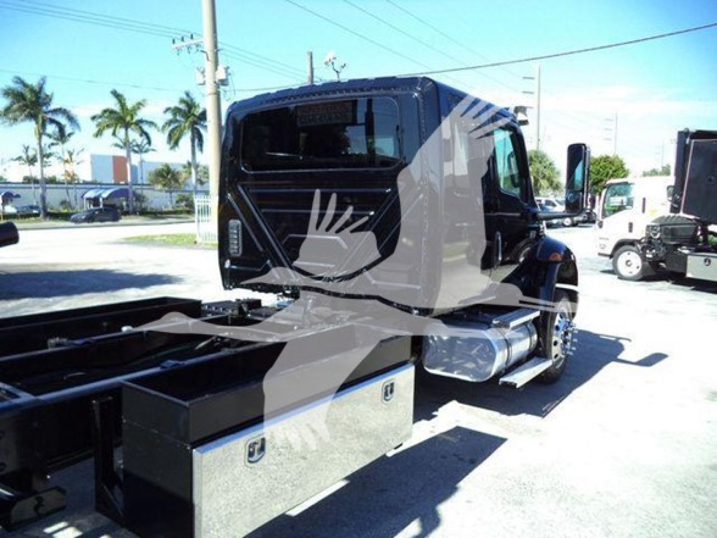 Truck cab of a 2022 International MV rollback truck showing side storage boxes and fuel tank, with VIN plate area not visible.