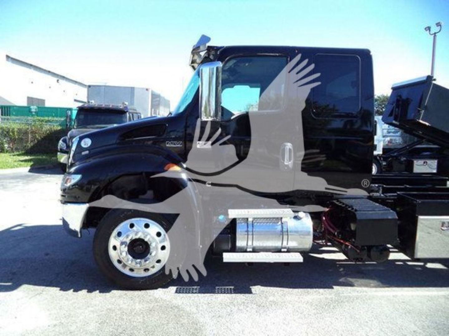 Truck cab side view showing chrome fuel tank and wheel on a 2022 International MV rollback truck.