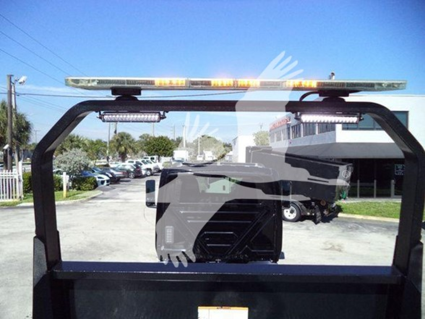 Truck rollback cab frame with light bar shows rear window area and cab in background. Some text/branding not legible.