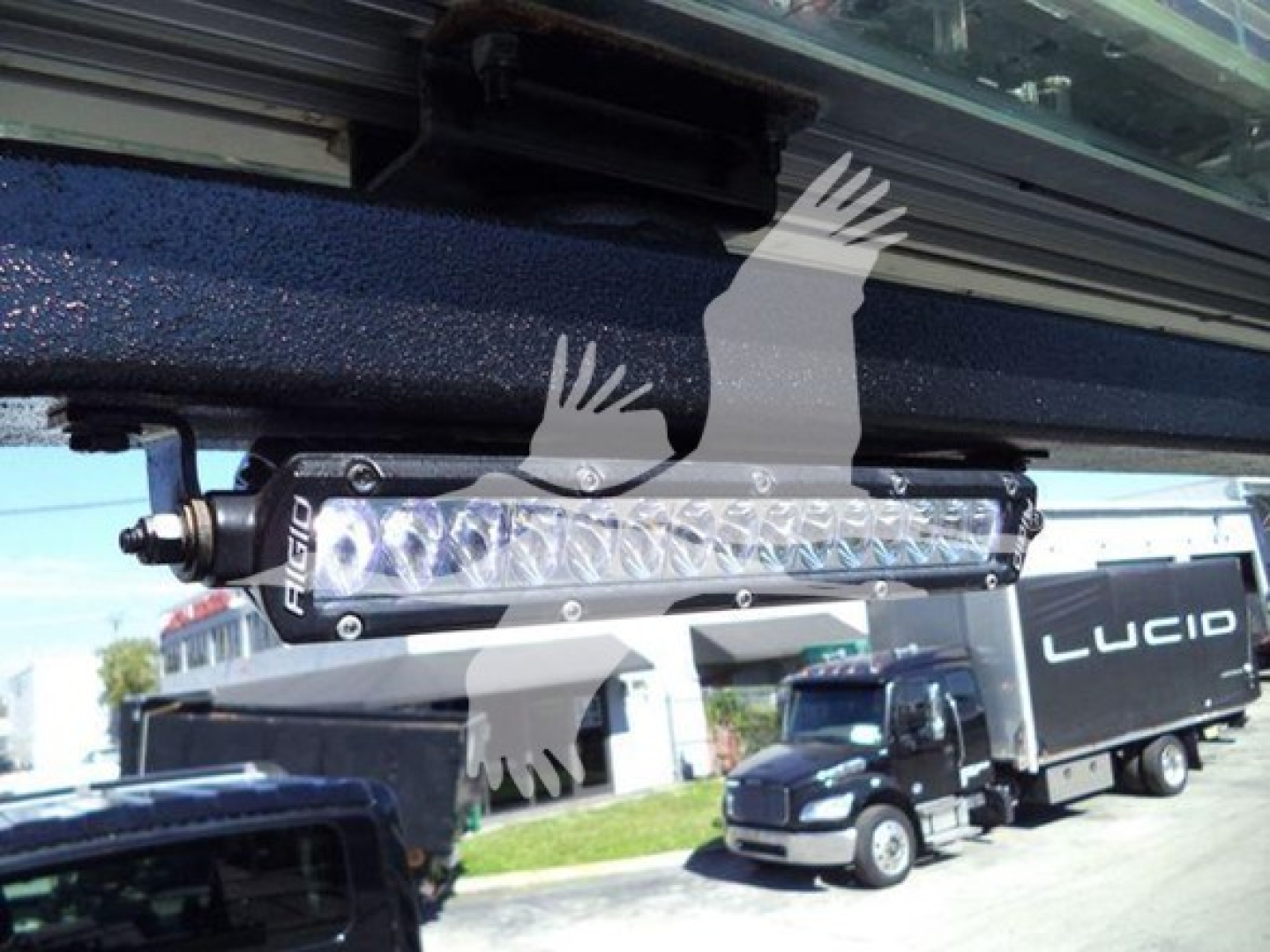 Light bar mounted under truck cab showing LED light bar with brand 'FUEL' on housing, against a rollback truck in background.