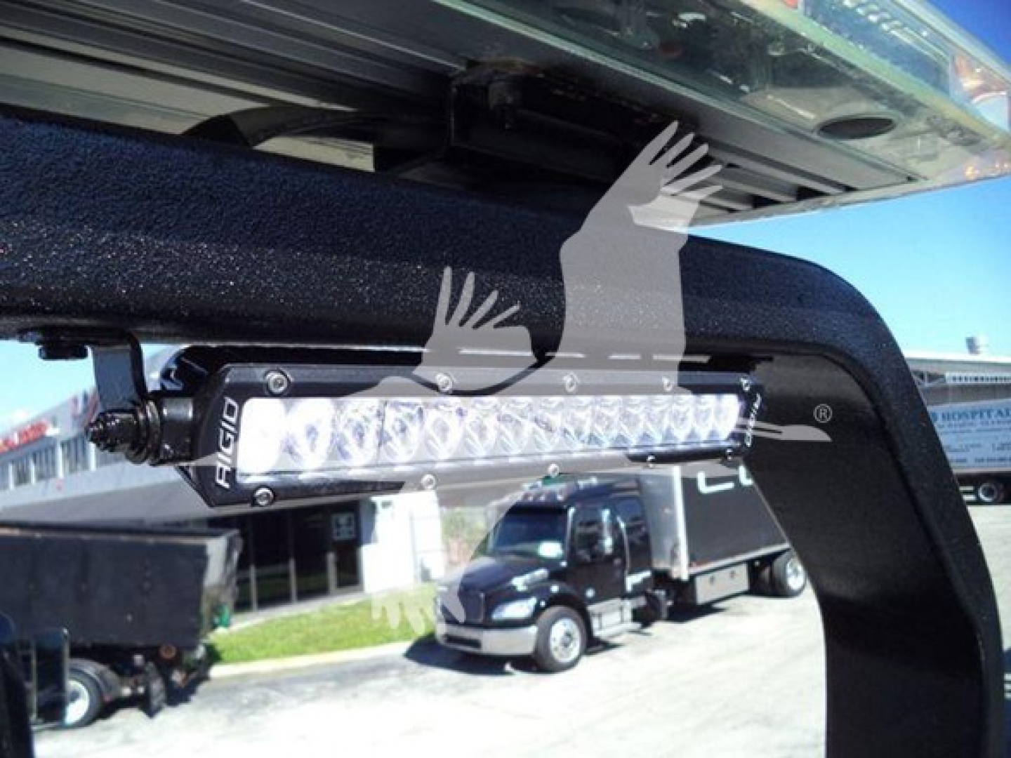 Light bar mounted under truck cab showing LED light bar with brand name AgID? (unclear) and wiring nearby.