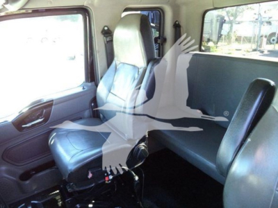 Interior of a 2022 International MV rollback truck showing front cab seat and rear seating with gray upholstery.