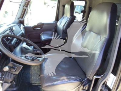 Truck cab interior showing steering wheel and two front seats in a manual transmission truck.