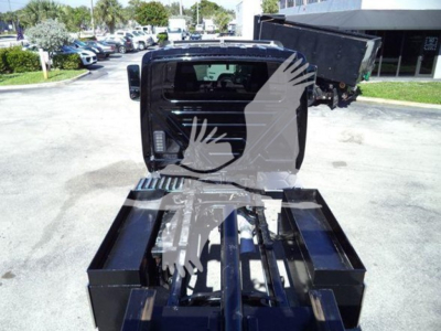 International MV rollback truck cab with open cargo bed and hydraulic system visible