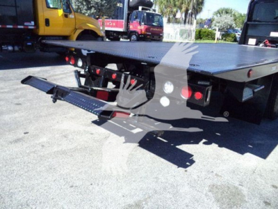 Truck bed with hitch and rear platform showing hydraulic ramp and taillights. Visible text includes no legible model numbers in image.