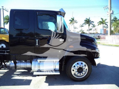 International MV rollback truck side view showing cab with black paint and chrome fuel tanks.
