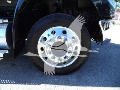 Truck wheel and chrome hubcap on a black International MV with partial front bumper visible.
