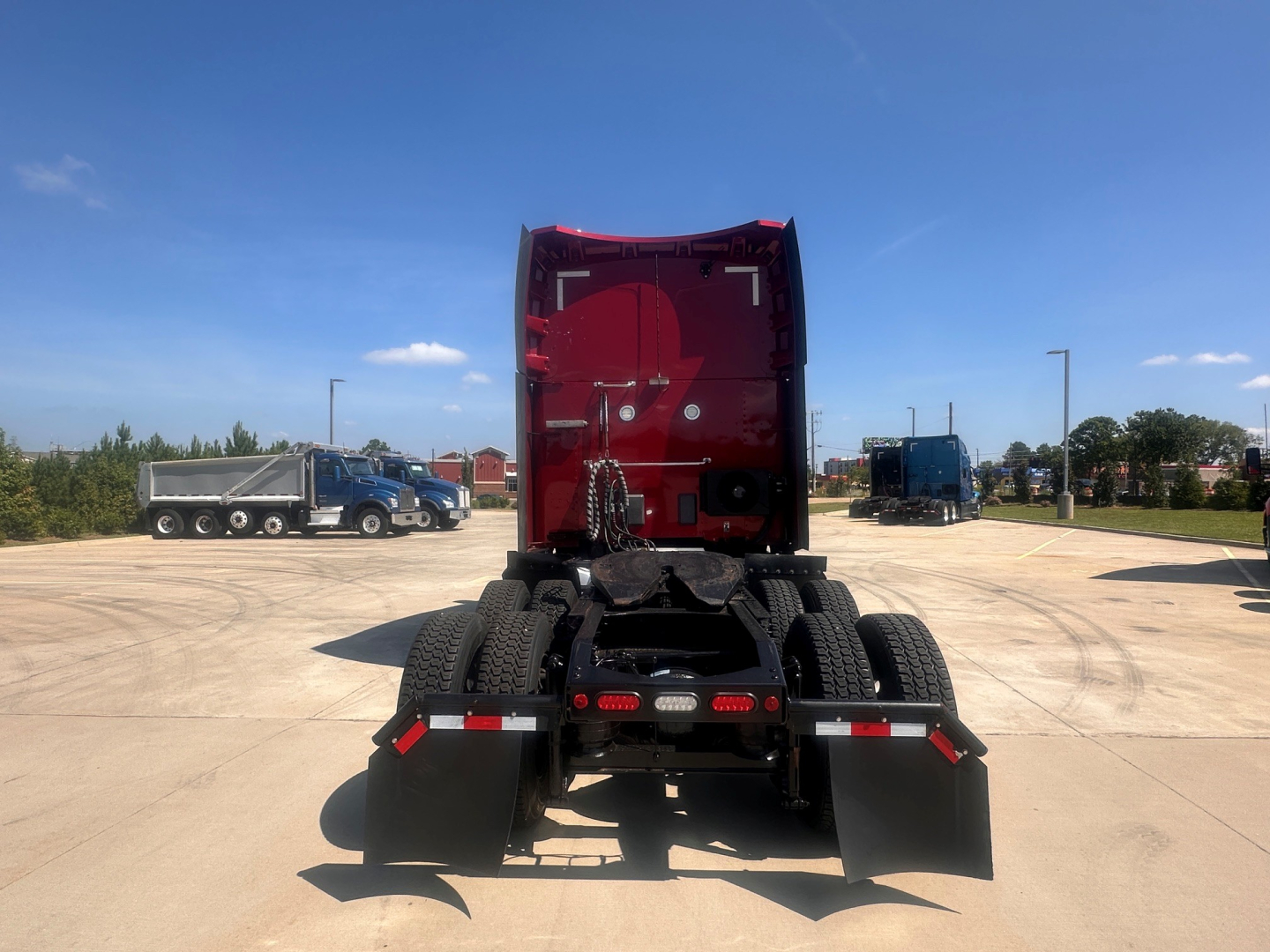 Peterbilt 579 tractor rear view showing fifth wheel and dual rear wheels in a parking lot.