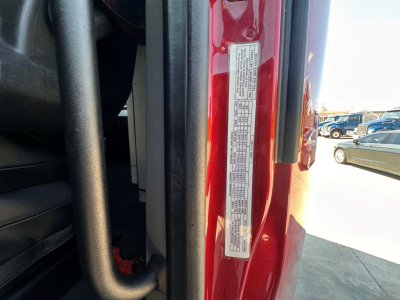 Peterbilt 579 cab interior view near door frame showing a narrow vertical label with small printed text on the red door jamb.