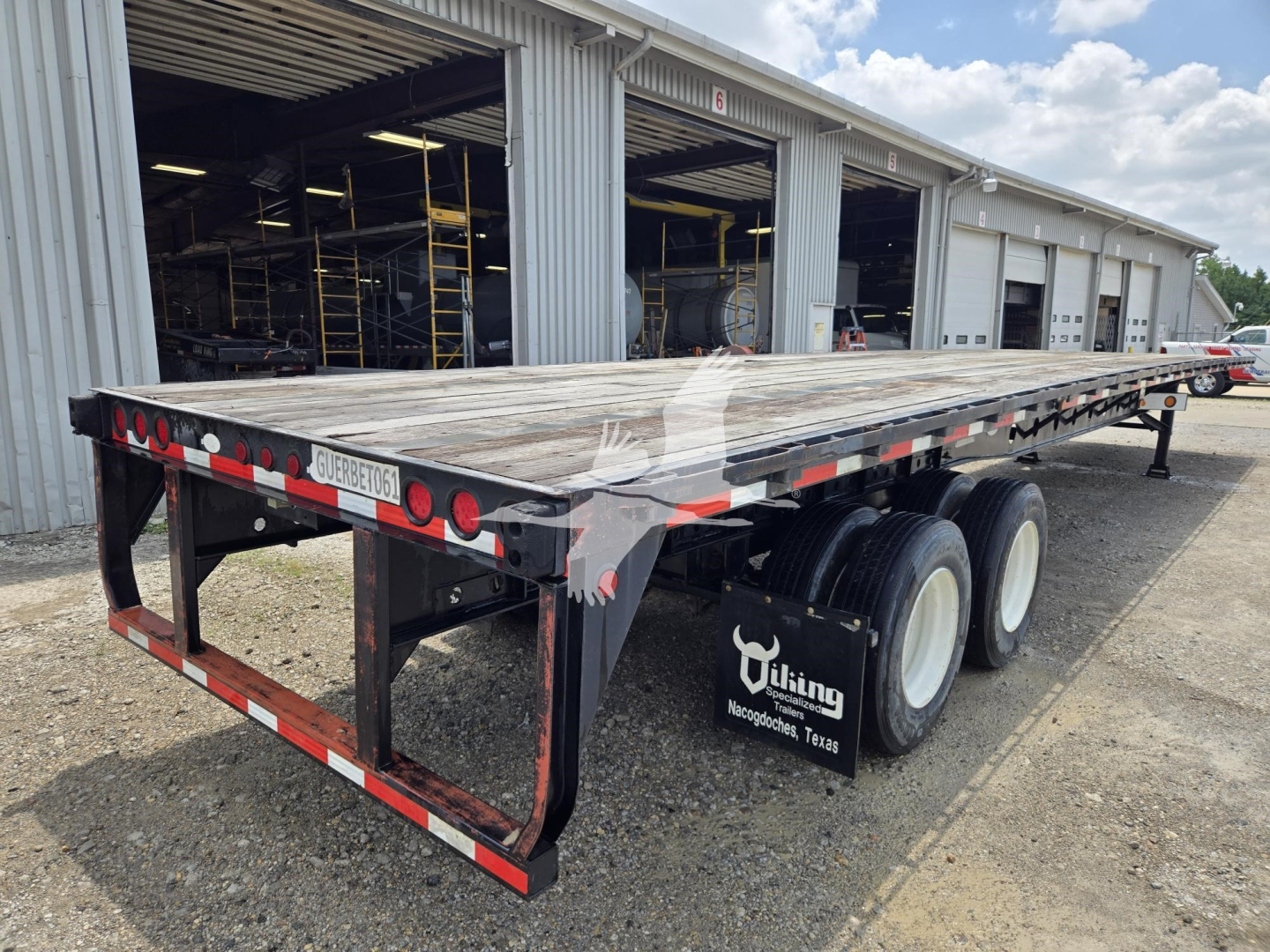 Trailer: 2015 Viking steel flatbed semi-trailer with triple axles, flat wooden deck, rear guard, and dual rear tires showing stock number 7843.