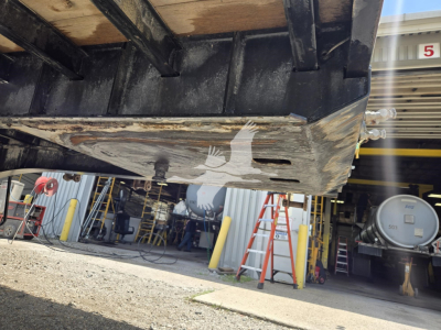 Underside of Viking flatbed trailer showing painted logo on steel beam and scratched metal edge.