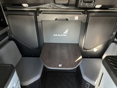 Mack PR64T76H interior showing seating area with fold-out table and Mack logo on center panel.