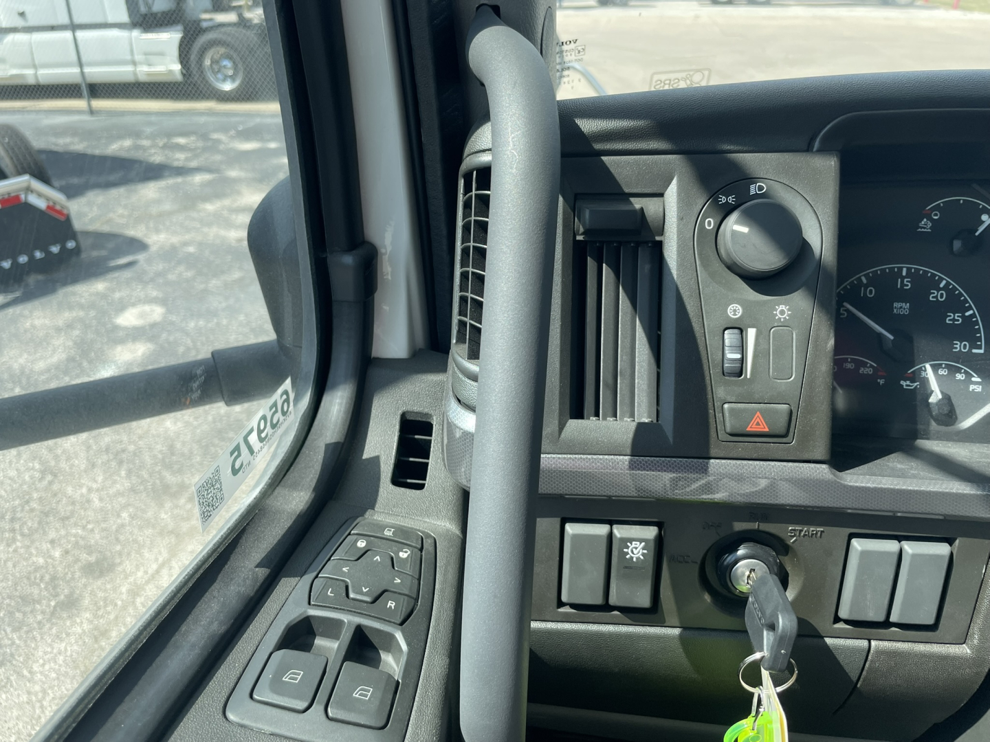 Volvo VHD86B300 cab interior showing steering wheel, control switches, ignition with key, and dashboard gauges.