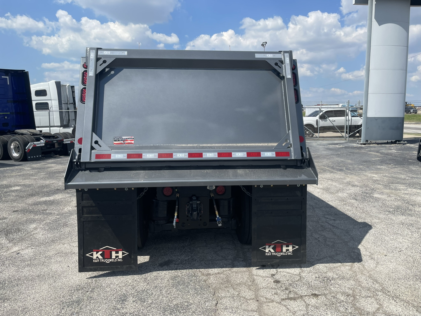 Back view of a 2025 Volvo VHD86B300 dump truck showing the tailgate and dual rear mud flaps with K&H branding.