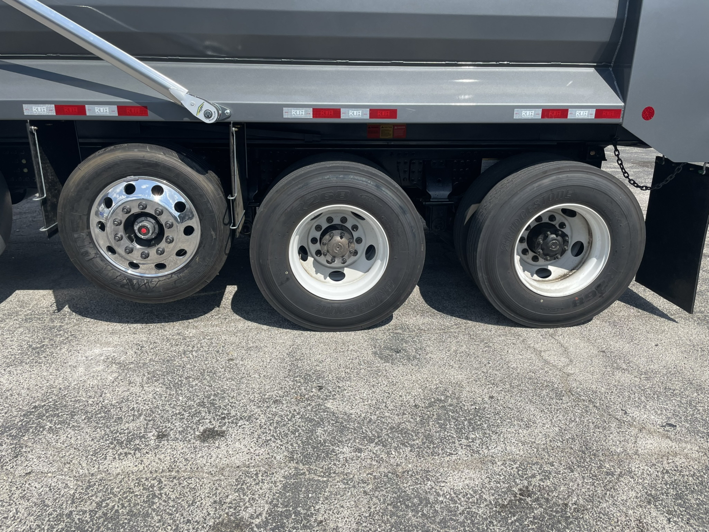 Three rear axles of a Volvo dump truck with wheels and tire rims visible. No legible labels or numeric markings readable on the tires themselves in the image.