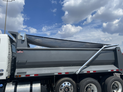 Volvo VHD86B300 dump truck side view showing dump bed and hydraulic arm. Visible text includes 'VHD' on side.