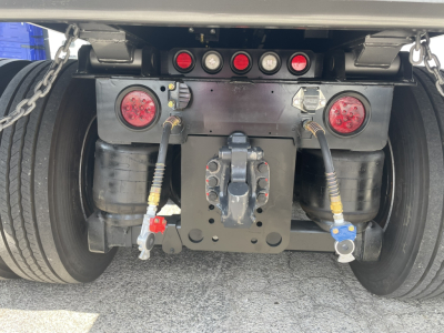 Volvo VHD86B300 rear view showing tow hitch assembly, air lines, and dual round red taillights with hoses and fittings.