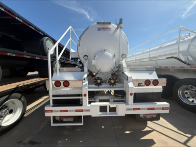 Dragon 140BBL vacuum trailer rear view showing circular tank, mounting ladder, safety rails, and rear bumper with lights.