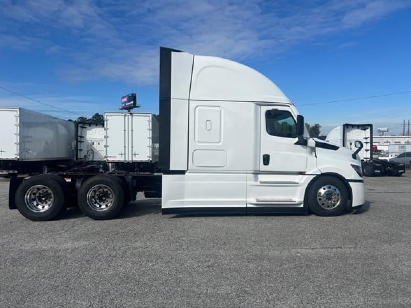 Freightliner Cascadia 126 tractor-trailer side view showing sleeper cab and dual rear axles.
