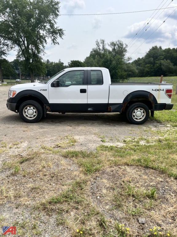 Ford F-150 extended cab pickup truck in white with black lower trim, 4x4 badge on rear quarter, two-tone body, side view showing crew cab doors and long bed.
