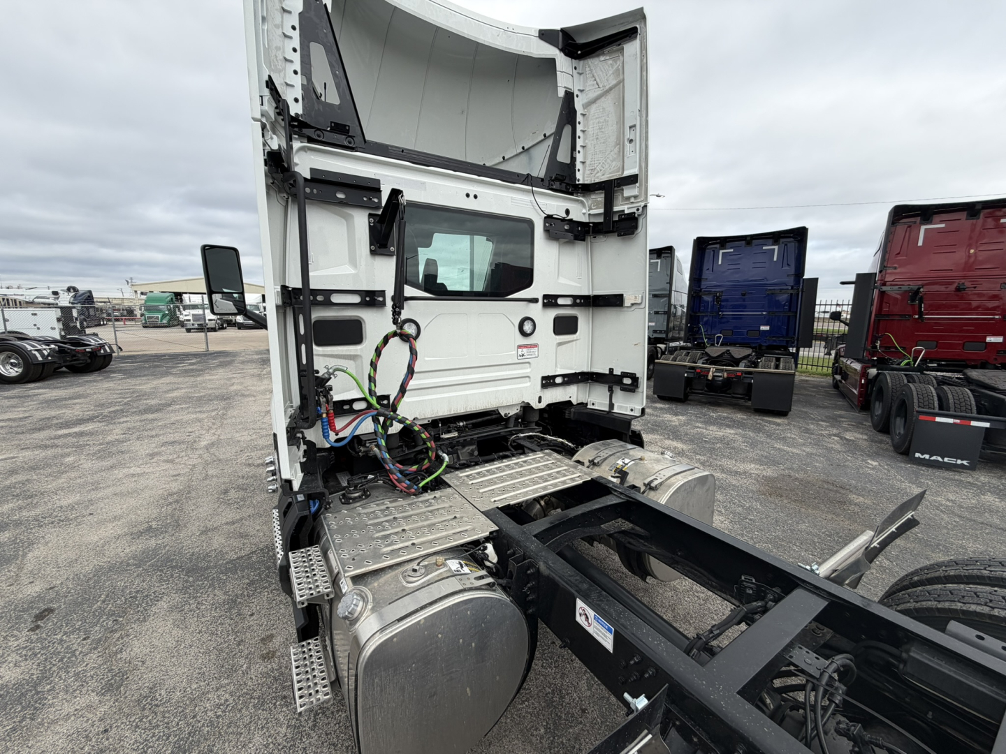 Truck cab rear view showing chassis and fuel tanks under the sleeper area of a Mack AN64T day cab.