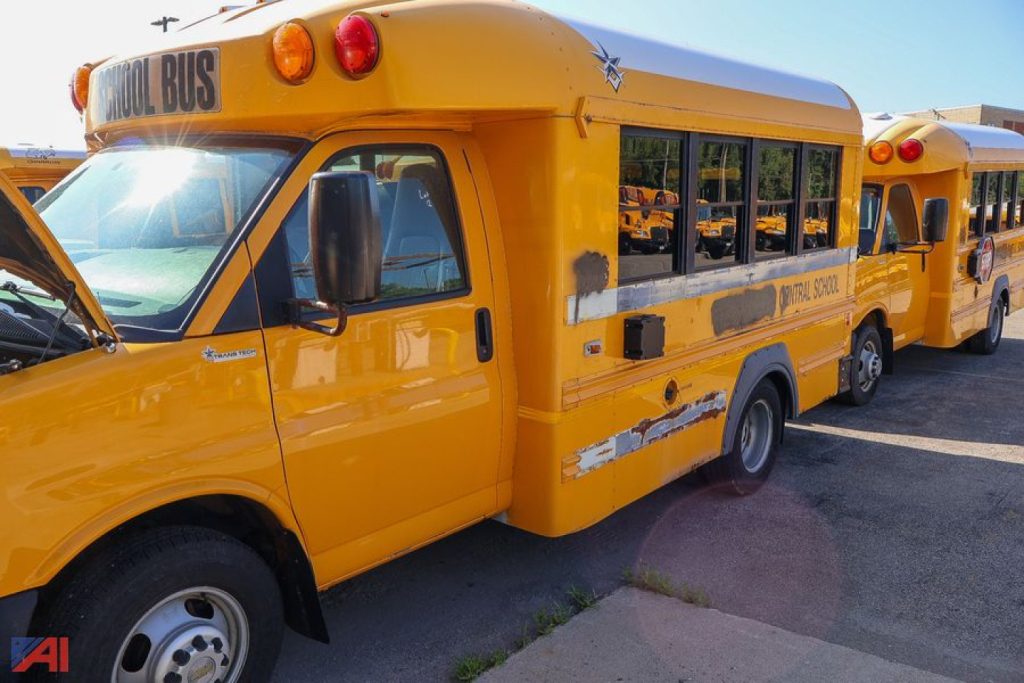 Yellow Express/Transit Tech school bus side view showing TRANS TECH markings and multiple doors