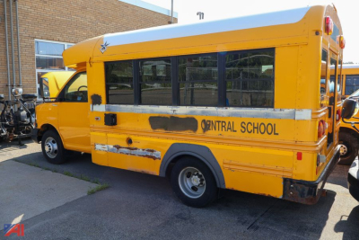 School bus side view with yellow transit style body, 'Central School' signage, black tinted windows, rear bumper and wheel.