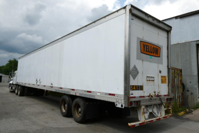 Trailer showing a white Great Dane 7411T-SSL with a yellow 'YELLOW' placard on the rear doors, dual rear axles, and safety decals on the back.