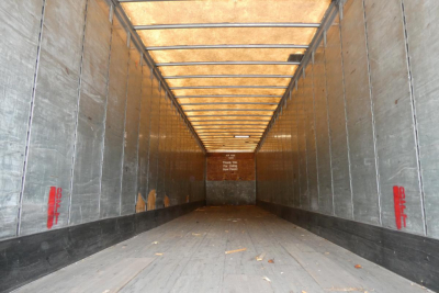 Great Dane trailer interior showing cargo area with wooden floor, aluminum sidewalls, and rear door, no visible text readable.