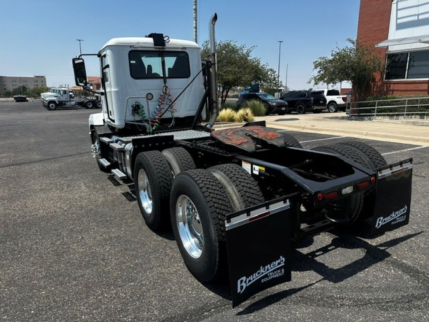 Truck chassis and rear view of a 2021 Mack Anthem conventional daycab. Dual rear axles with mud flaps, aluminum wheels, fifth-wheel and cable lines visible.