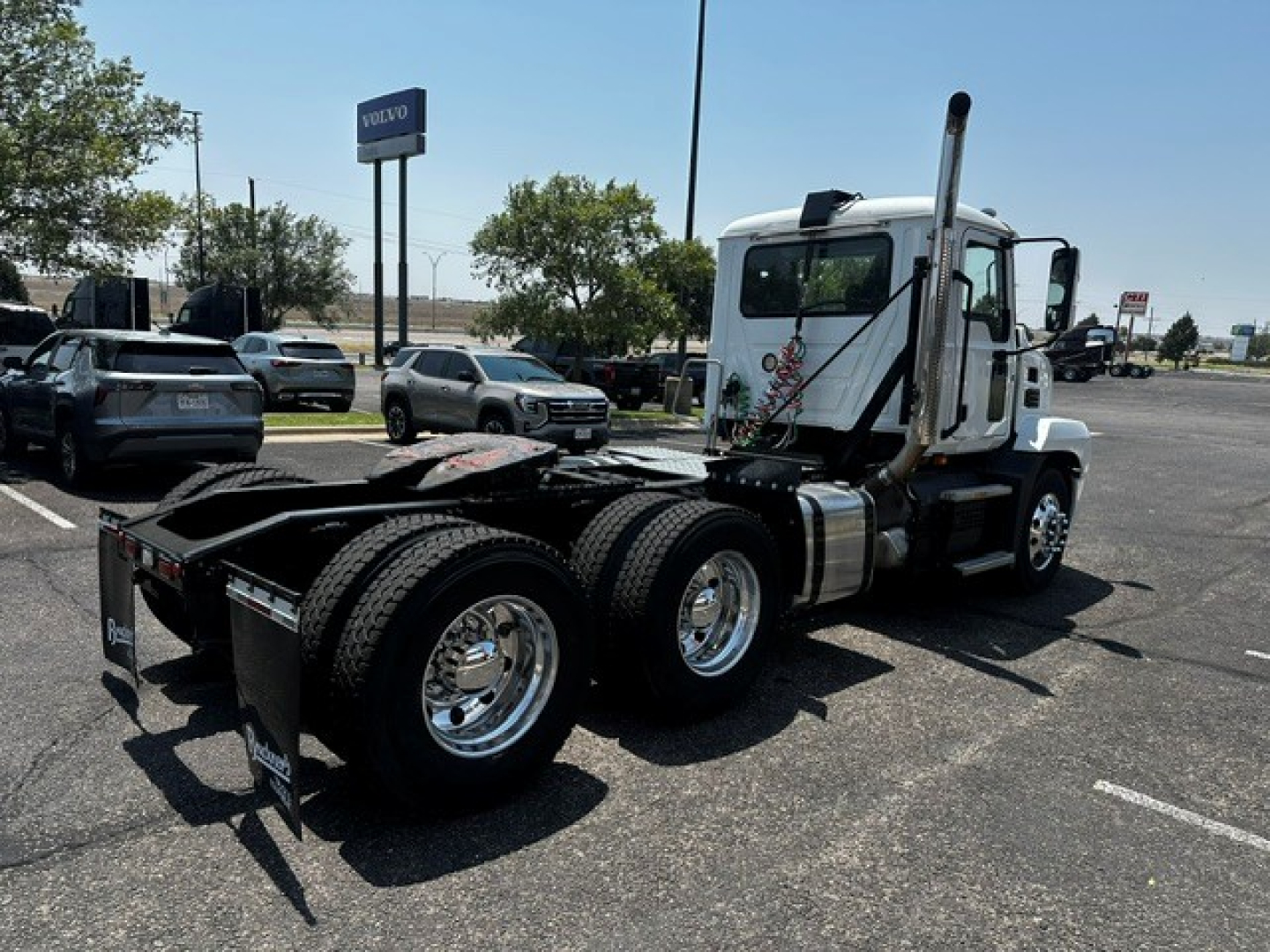 Truck chassis and cab of a 2021 Mack Anthem seen from side rear, showing dual rear axles, fifth-wheel area, and exhaust stack.