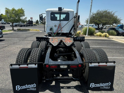 Truck chassis rear view showing dual rear axles and fifth wheel mounting with Bruckner's Truck Equipment branding on mud flaps.