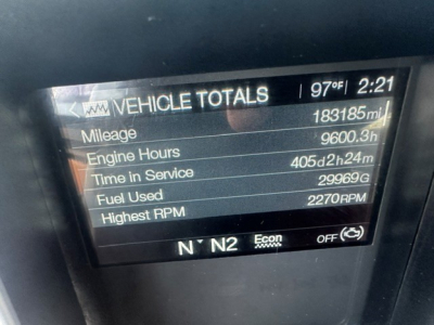 Truck instrument cluster display showing Vehicle Totals with mileage 183185 mi, engine hours 9600.3 h, time in service 405d2h24m, fuel used 299669, highest RPM 2270 RPM.