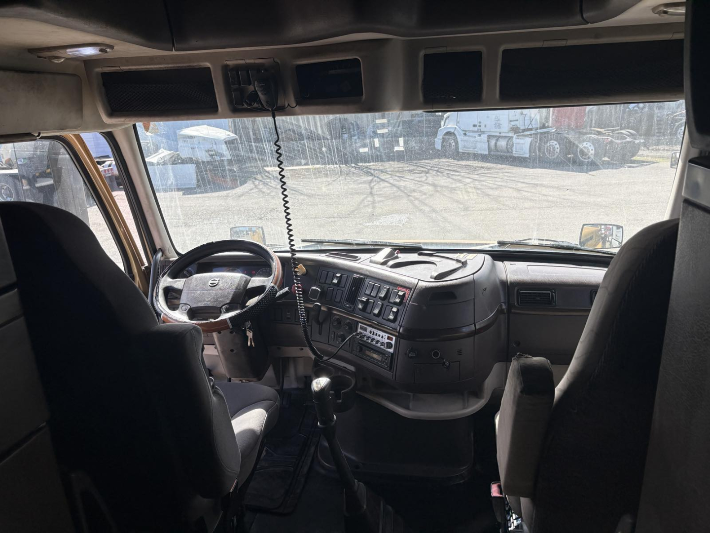 Cab interior of a 2013 Volvo 770 truck showing steering wheel and dashboard with gear shifter and seating