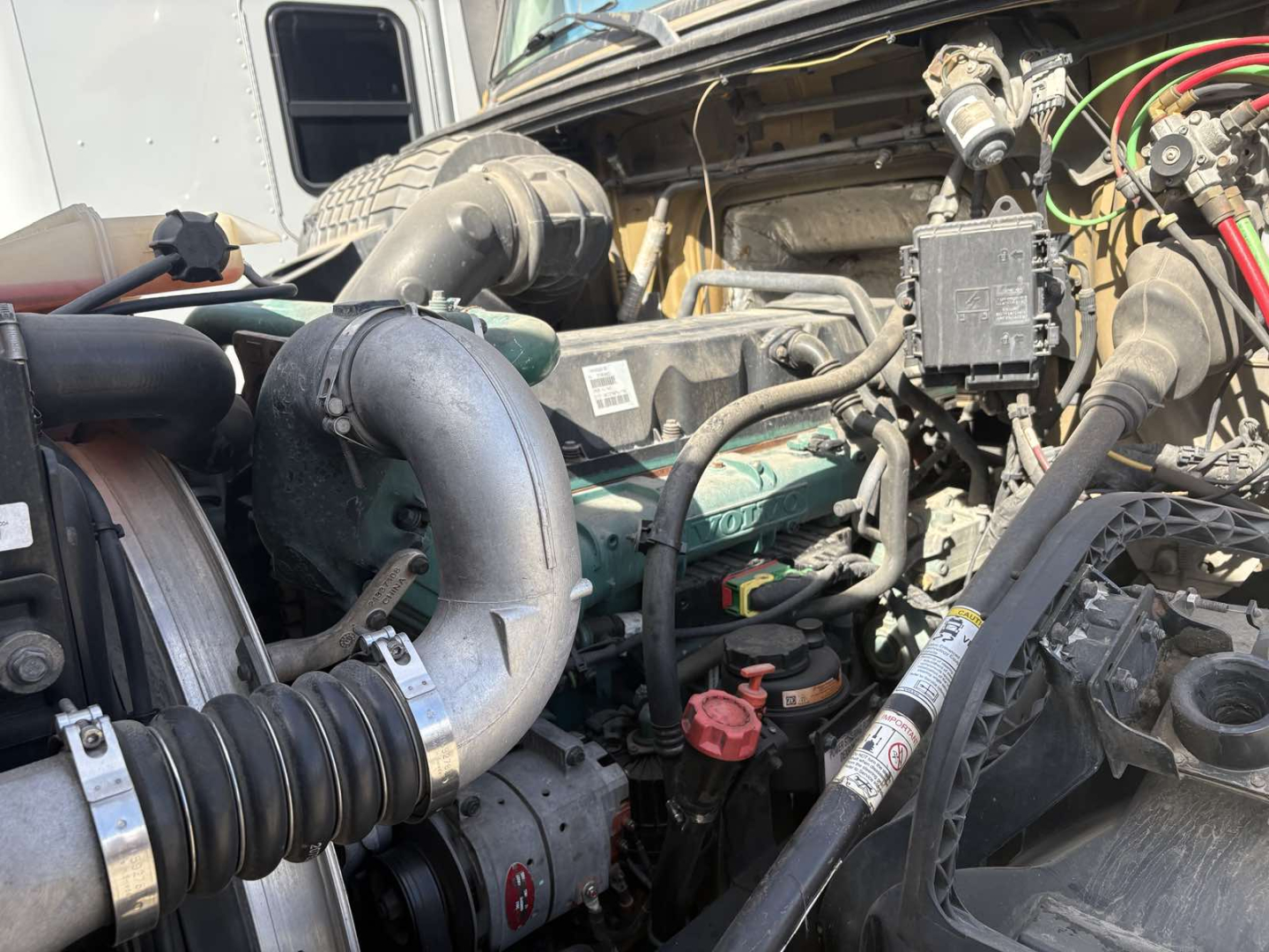 Volvo 770 engine bay with air intake hose, turbo, hoses, wiring, and engine components visible in a sleeper truck.