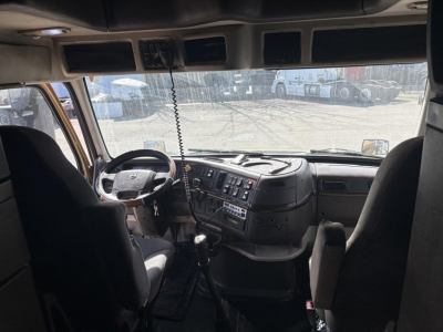 Cab interior of a 2013 Volvo 770 truck showing steering wheel and dashboard with gear shifter and seating