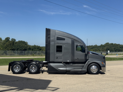 Kenworth T680 tractor side view showing sleeper cab, gray paint, dual rear axles, chrome wheels, and side fuel/air tanks.