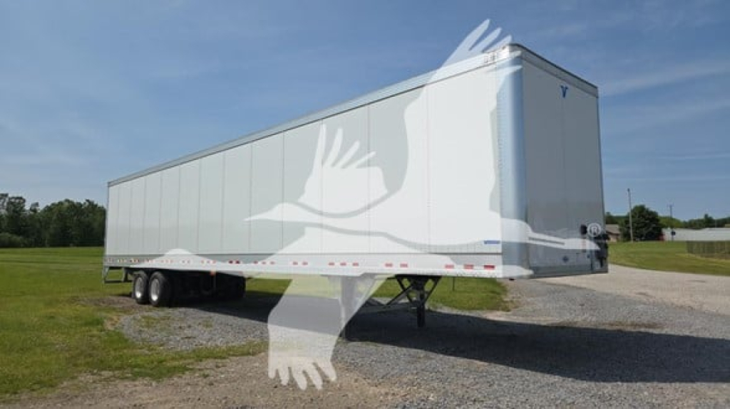 Vanguard VXP Highbase Rail trailer in a yard showing side and rear with dual wheels and landing gear.