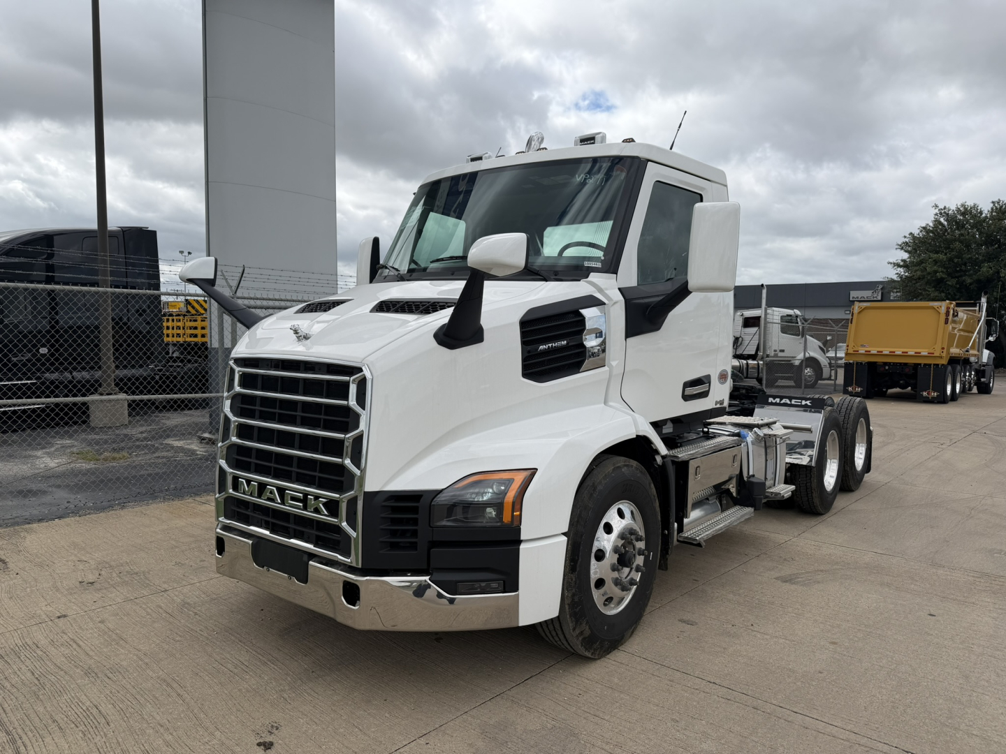 Mack AN64T conventional daycab truck in white, front three-quarter view showing grille, headlights, and side mirrors.
