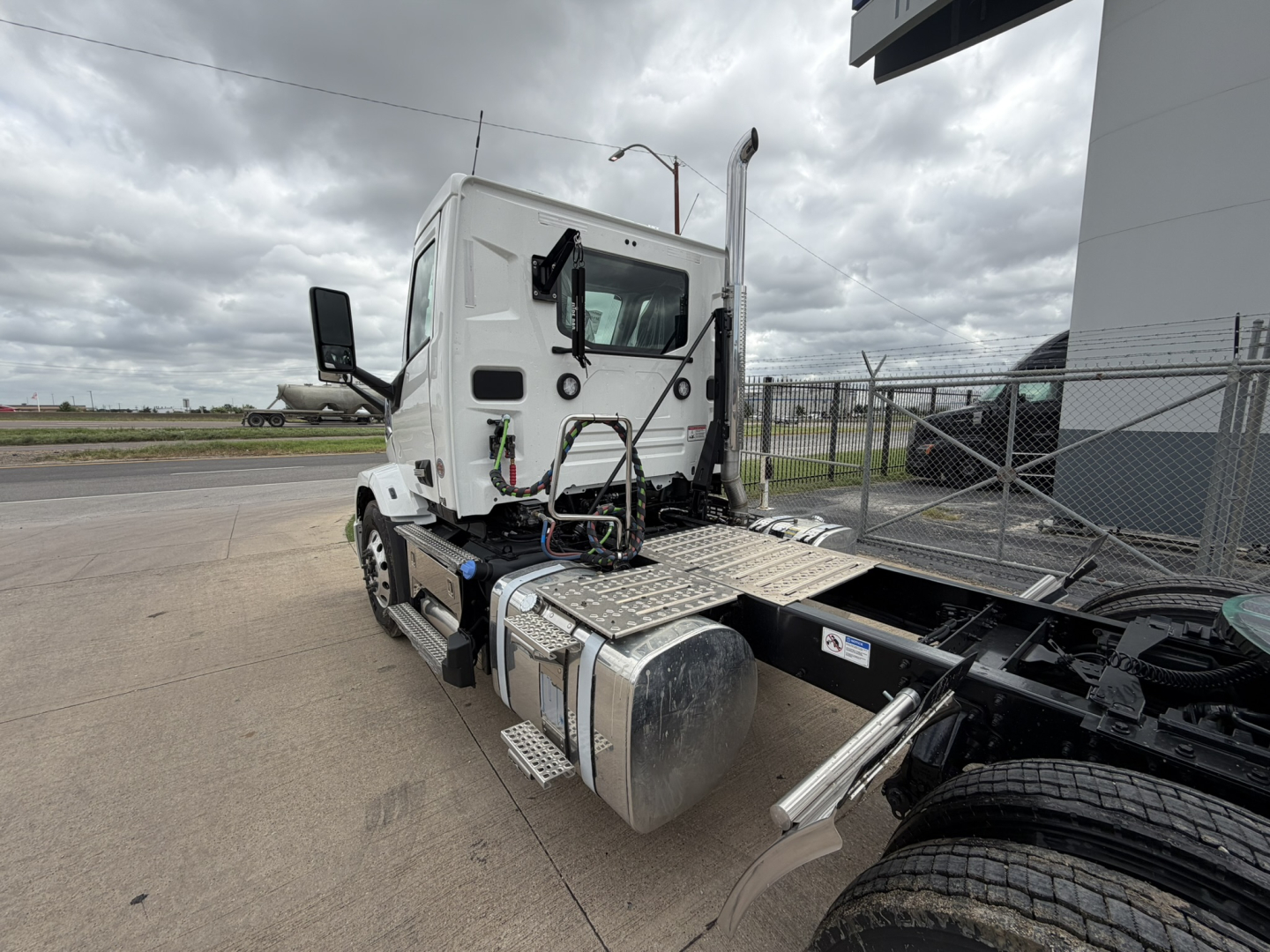 Mack AN64T truck cab and chassis showing fuel tanks and side steps with Midland area background.