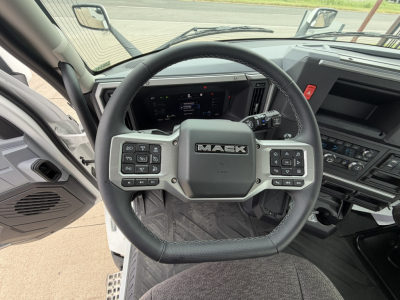 Steering wheel inside Mack AN64T cab with dashboard display; visible buttons on steering wheel and center console.