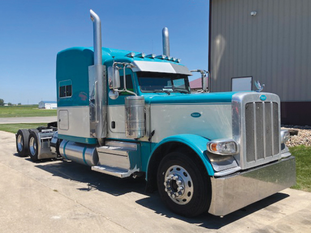 Peterbilt 389 UltraCab Extended Hood truck in teal and silver, side view showing chrome exhaust stacks and fuel tanks
