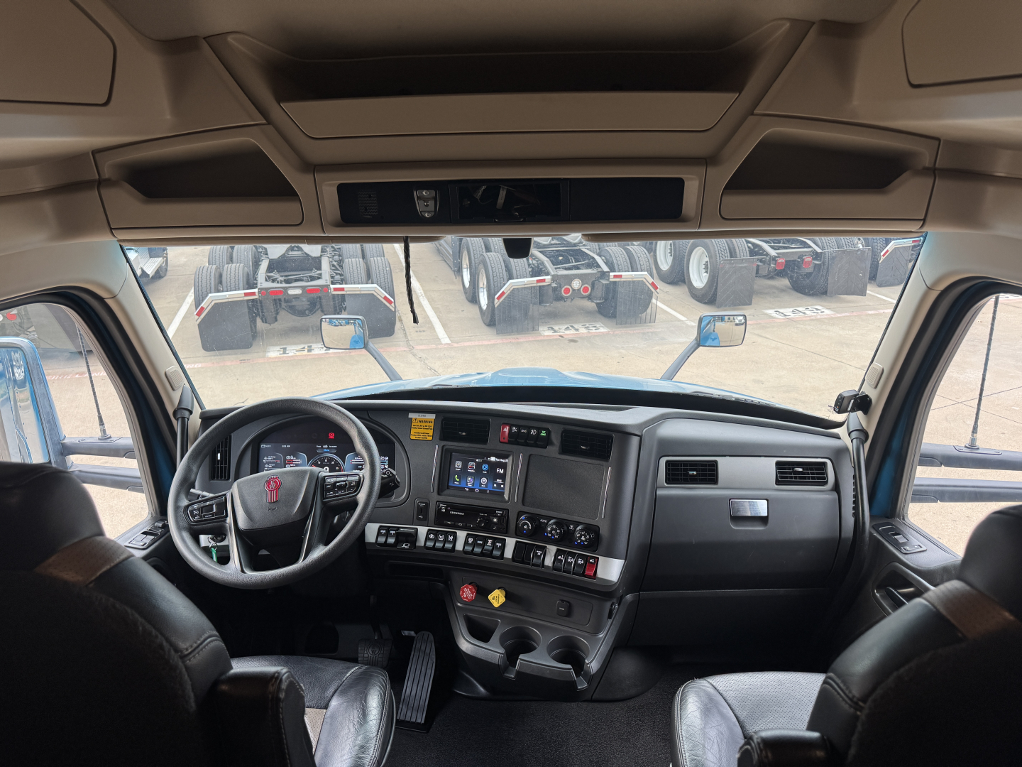 Kenworth T680 truck cab interior dashboard view with steering wheel, instrument cluster, center console, and dashboard controls.