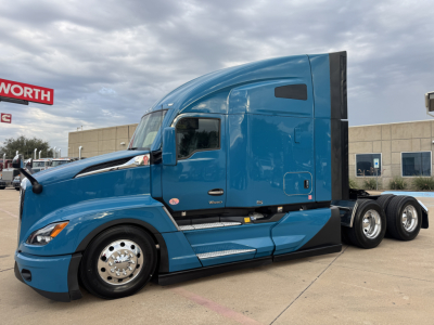 Kenworth T680 truck in blue, side view showing cab with sleeper, front wheel, chrome rims, and dual rear axles.