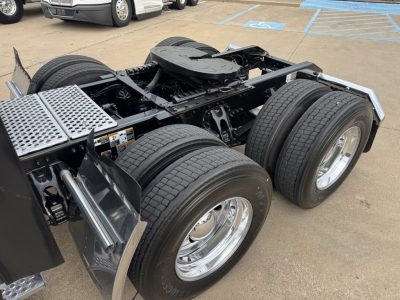 Kenworth T680 chassis showing dual rear axles and fifth wheel area with fuel tank and aluminum diamond plate step.
