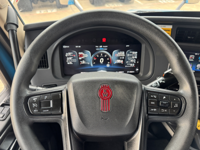 Kenworth T680 interior steering wheel and digital instrument cluster showing controls and dash display.