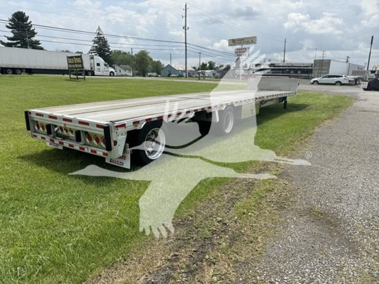 Dropdeck trailer showing rear and side views with reflective taillights and dual axles.